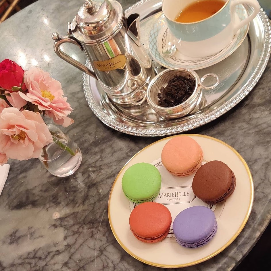 Macarons, tea on a silver tray, and flowers