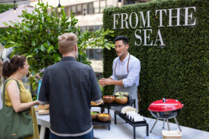 Grillmaster John Lee presenting the From The Sea menu at the ALDI Summer Grill Out, including salmon tacos and Mexican street corn.